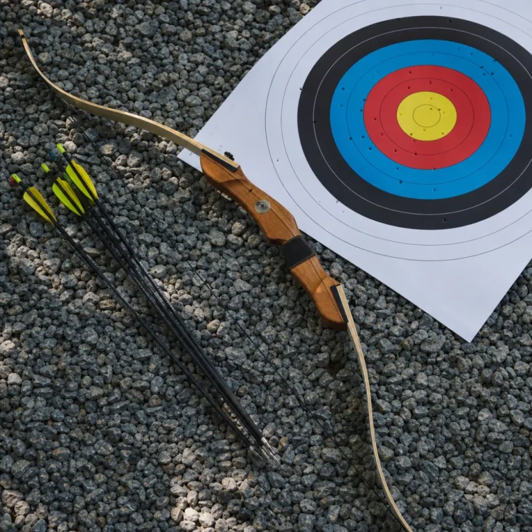 A recurve bow with arrows and a target face