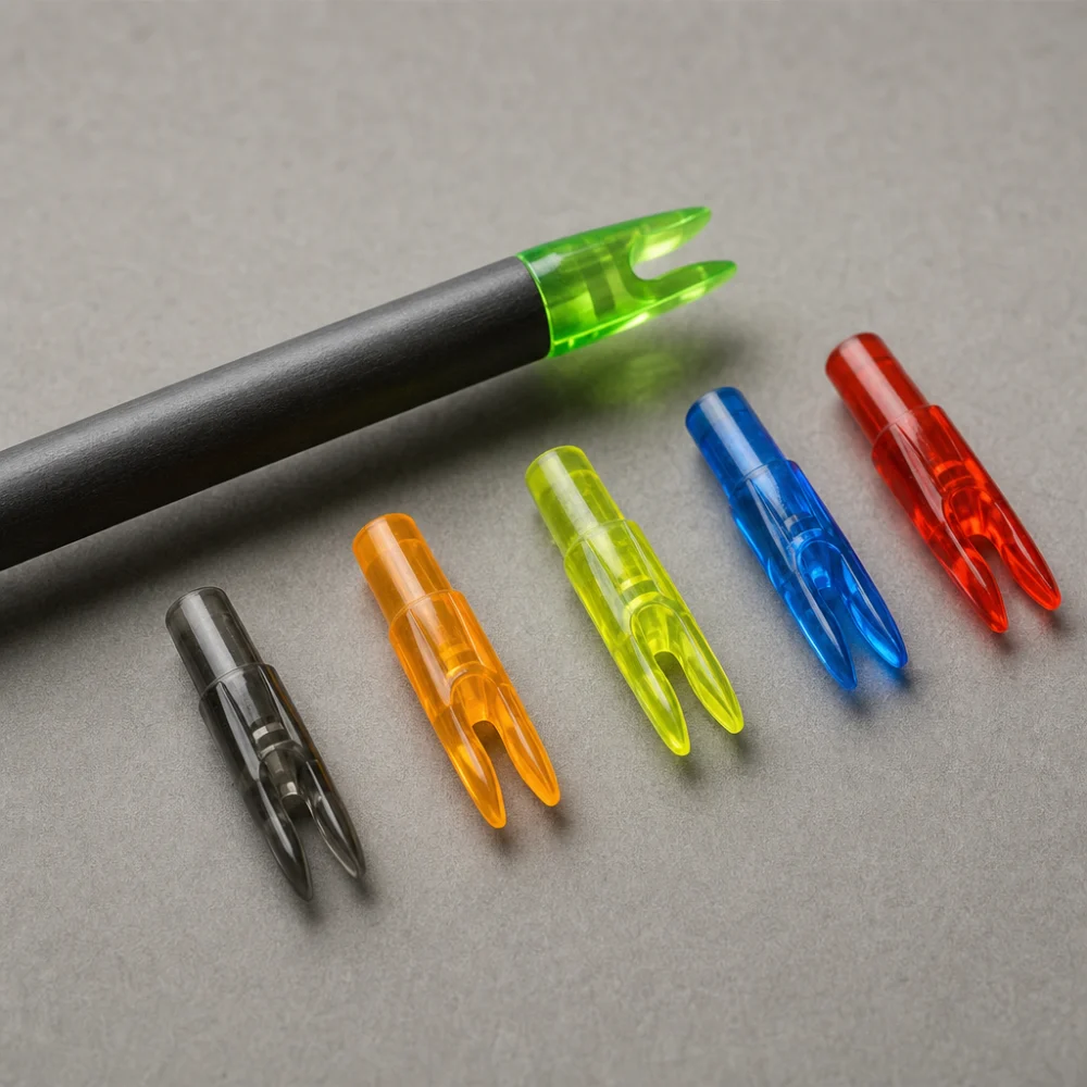 Several arrow nocks arranged beside an arrow shaft on a neutral background.