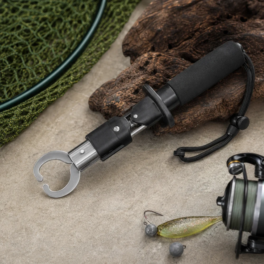 A generic fish gripper beside basic fishing tackle on a neutral surface.
