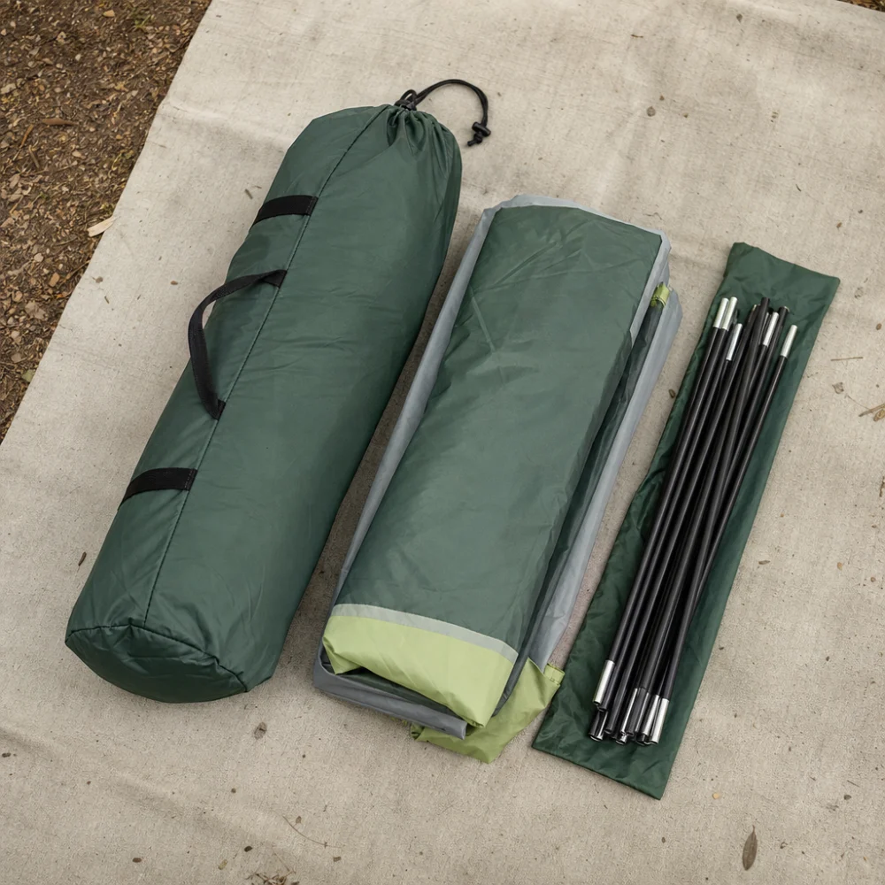 A tent storage bag with folded camping tent parts arranged beside it.